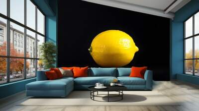 Vibrant Yellow Lemon Against a Bold Black Background Wall mural