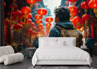 Young traveler embraces adventure in bustling street market under vibrant red lanterns Wall mural