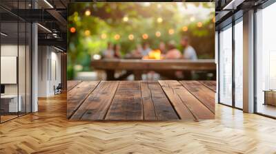 Empty wooden table and blurred view of people having BBQ barbecue with modern grill outdoors Wall mural