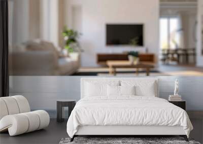 frontal view shot of empty white table in living room,  white blurred living room with tv and furniture in the background Wall mural