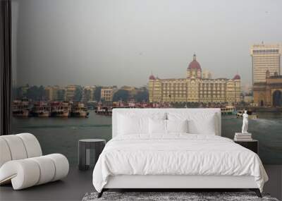 Mumbai city skyline in the evening taken from joy boat ride in the Arabian sea and iconic gateway of india and Taj Mahal hotel in view  Wall mural