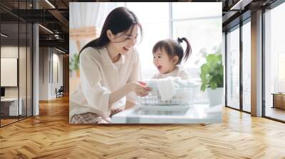 Beautiful Asain woman is happy doing housework accompanied by a cute baby Wall mural