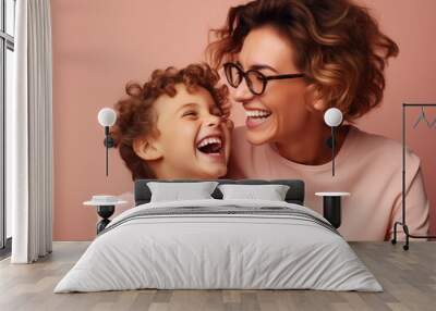 Photograph of mother in glasses with her little son wearing pink t-shirt on pastel pink background Wall mural