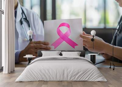 A doctor showing a breast cancer patient a brochure on treatment options, with a pink ribbon prominently displayed on the cover, the scene is set in a professional office with bright natural light Wall mural