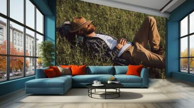 Bearded explorer sleeping on grass Wall mural