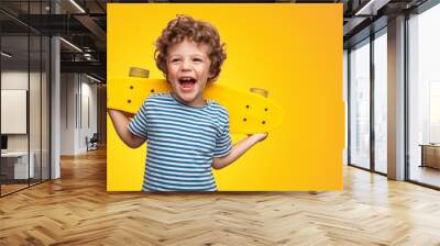 Bright curly boy with colorful longboard  Wall mural