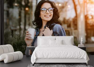 Cheerful coffee lover walking on street Wall mural