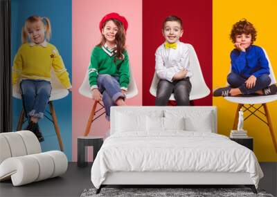 Cheerful kids in stylish clothes sitting on chairs Wall mural