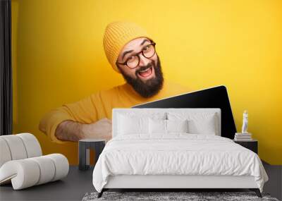 Cheerful man pointing at laptop Wall mural