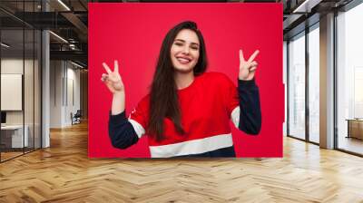 Cheerful woman gesturing peace Wall mural