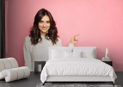 Cute young woman points a finger away Wall mural