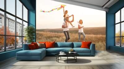 Delighted family playing with kite Wall mural