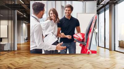 Male manager selling car to couple Wall mural