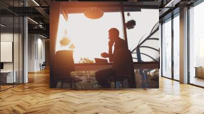 Silhouette of a man working in cafe Wall mural