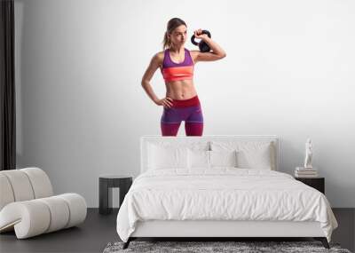 Slim female exercising with kettlebell Wall mural