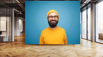 Smiling happy bearded hipster on blue Wall mural