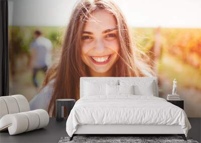 Smiling teenage girl outdoors on sunny day. Closeup of cute brunette young woman wearing casual clothes. Wall mural