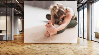 Young woman performing Janusirsasana exercise Wall mural