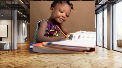 African Girl child studying alone with books on her table   Wall mural