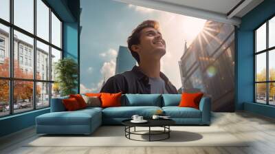 A happy young caucasian man looking up at the sky alone in a busy city, sun shining Wall mural