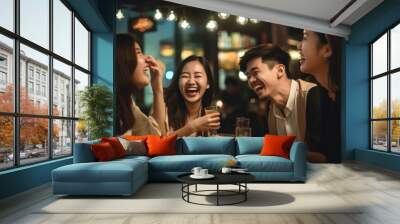 Asian adults laughing and drinking having fun at a party in a bar Wall mural