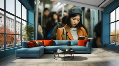 Asian girl in a busy train scrolling on her smart phone Wall mural