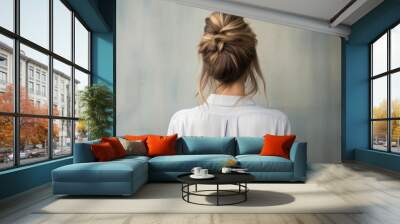 Back view of a girl head with hair in a messy bun hairstyle and simple top Wall mural