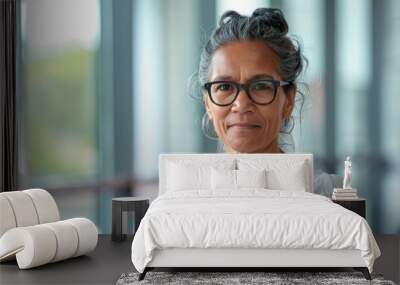 Beautiful 45 years old gentle aboriginal Australian woman, wearing glasses, formal slick hairstyle, smooth face in a modern office building, wearing white shirt, beside a huge window Wall mural