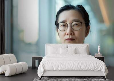 Beautiful 45 years old gentle Chinese Han woman, wearing glasses, formal slick hairstyle, smooth face in a modern office building, wearing white shirt, beside a huge window Wall mural