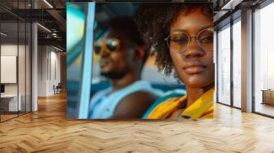 Beautiful afro american woman and a handsome black man forming a trendy modern couple outdoor with a luxury car like in a movie Wall mural