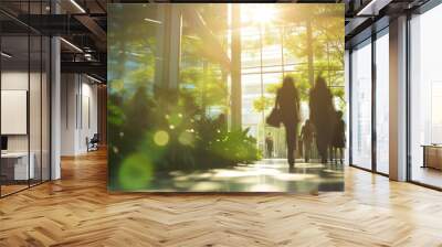 Blurred background of people walking in a modern office building with green trees and sunlight , eco friendly and ecological responsible business concept image with copy space Wall mural