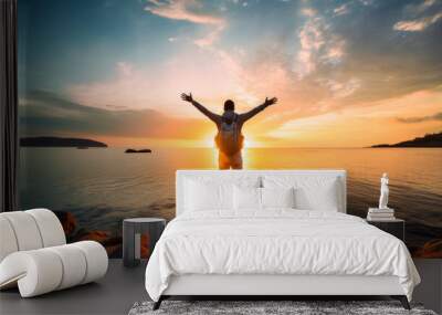 Confident man with backpack with arms up relaxing at sunset seaside during a trip , male traveler enjoying freedom in serene nature landscape Wall mural