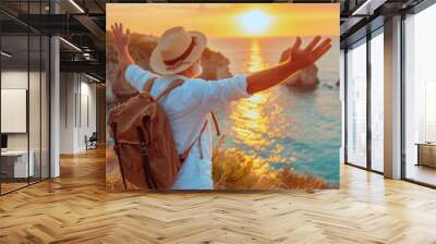 Confident mature man with backpack with arms up relaxing at sunset seaside during a trip , old male traveler enjoying freedom in serene nature landscape Wall mural