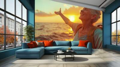 Confident mature woman with backpack with arms up relaxing at sunset seaside during a trip , old female traveler enjoying freedom in serene nature landscape Wall mural