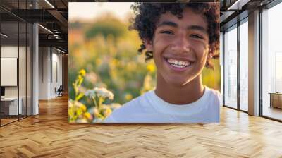 Happy 15 years old teenage boy portrait in middle of beautiful nature of a field with copy space Wall mural