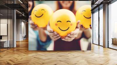 Happy people, happy group. Holding yellow smiley in their hands. Smiling face happy individual, positivity at work or team concept Wall mural