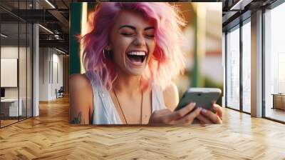 Happy young woman with colored hair colorful clothes and a smart mobile phone in her hands laughs and screams with joy while looking at the device screen Wall mural