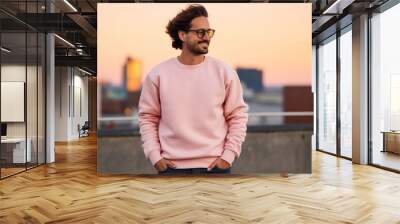 Man wearing a high-quality Flat Blank Plane crewneck Light Pink color Sweatshirt Mockup with oversized look and sunglasses and nature mountain background Wall mural