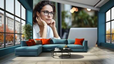 Pensive professional woman thinking at work in front of her laptop computer Wall mural