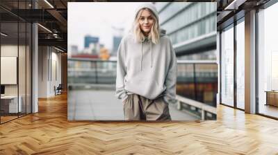 Portrait of a beautiful young adult woman wearing oversized style clothes in city street Wall mural