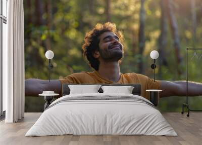 Portrait of a free happy Indian man with open arms enjoying life in meadows and nature background , young joyful asian male with good mental health Wall mural