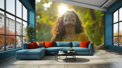 Portrait of a free happy Indian woman with open arms enjoying life in meadows and nature background , young joyful asian female with good mental health Wall mural