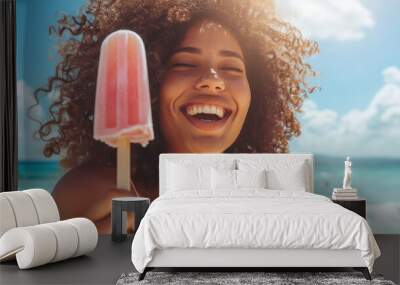 Portrait of a young smiling African American woman eating a popsicle ice cream on hot summer day at the beach Wall mural