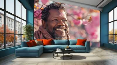 Portrait of an handsome black Afro American man posing in front of a blooming cherry tree , close-up view of a cheerful beautiful African black middle aged male in an outdoor park Wall mural