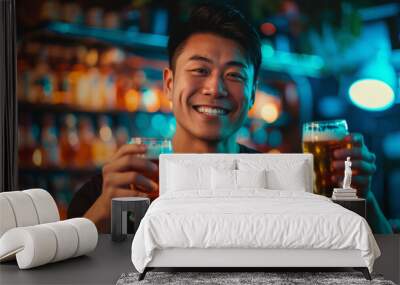 portrait of an happy smiling asian young man wearing a black tee, standing in a bar while holding tw Wall mural