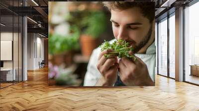 Professional cook chef smelling the freshly cut aromatic herbs to prepare flavored dish Wall mural