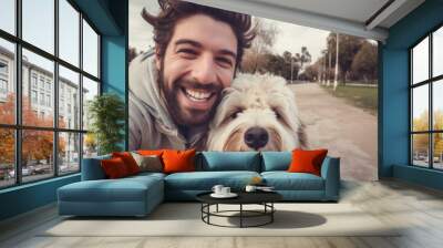 Selfie picture of a young happy man walking his dog in a park , smiling guy and pet having fun together outdoor , friendship and love between humans and animals Wall mural