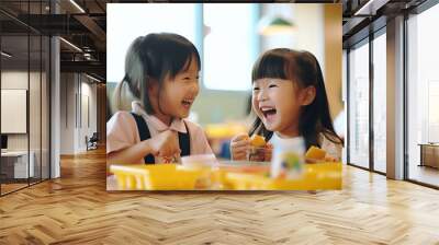 Two Asian elementary school students joyfully sharing a meal together, their faces beaming with happiness and laughter Wall mural