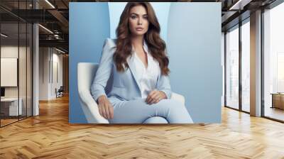 Woman with dark brown long wavy hair, wearing elegant light color pantsuit, sitting a modern chair, wearing white pumps, white and light blue fashion photography Wall mural