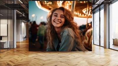 Young happy smiling teenage girl at a carnival with colorful carousel ride in background , fair or funfair concept image Wall mural